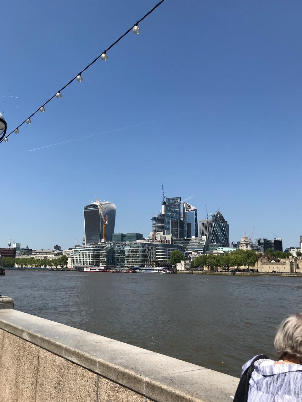 CITY BUILDINGS BY RIVER AGAINST CLEAR SKY