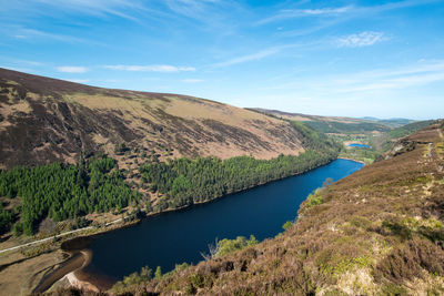 Scenic view of lake by mountain against sky