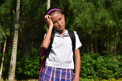 Full length of teenage girl standing against trees