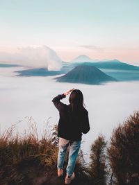 Rear view of man photographing against sky