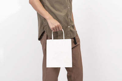 Low section of woman standing against white background