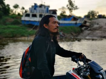Portrait of asian man with long hair on river background