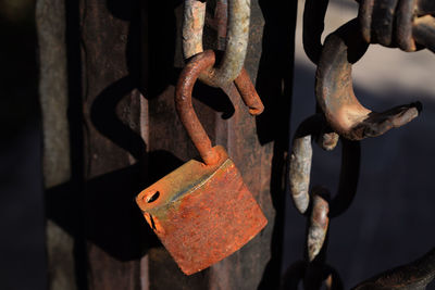 Close-up of rusty padlock hanging on metal