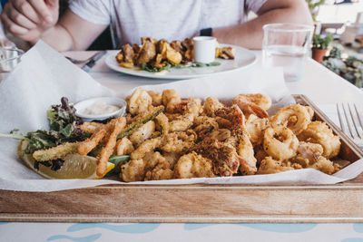 Frito misto, battered deep fried seafood, served on a tray in a restaurant.