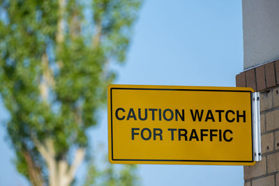 Low angle view of road sign against clear sky