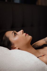 Close-up of woman lying on bed at home