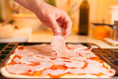 Close-up of hand holding food in baking sheet