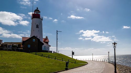 Lighthouse by sea against sky