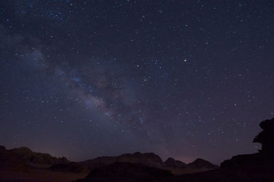 Low angle view of silhouette mountain against sky at night