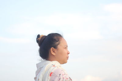 Portrait of asian woman looking away against sky