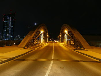 Illuminated bridge against sky at night
