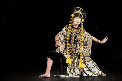 Man with umbrella standing against black background
