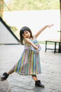 Full length portrait of girl standing outdoors