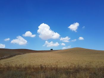 Scenic view of field against blue sky