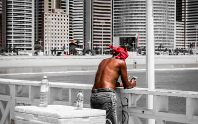 Midsection of a man skateboarding in front of building