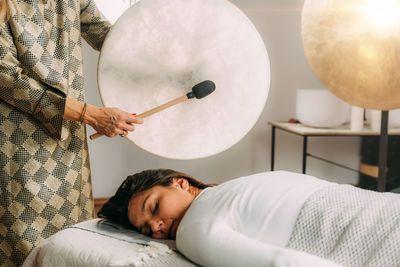 Sound therapy drum. playing native american hide drum in sound healing therapy