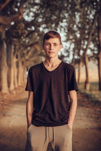 Portrait of young man standing in forest