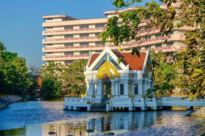 Building by lake against sky