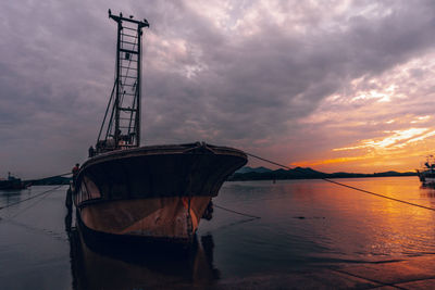 Ship moored on sea against sky during sunset