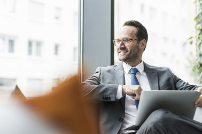 Businessman sitting in lobby using laptop