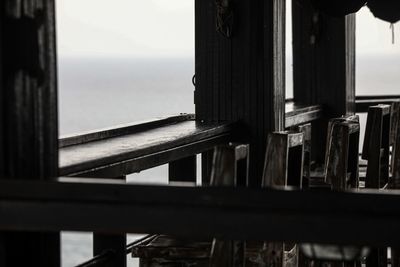 Close-up of railing by building against sky