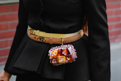 Midsection of woman standing against wall