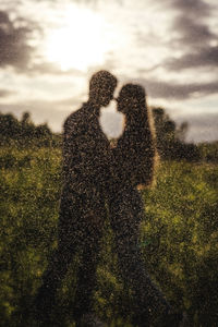 Shadow of man and woman standing on field