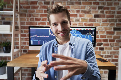 Portrait of smiling businessman gesturing at home