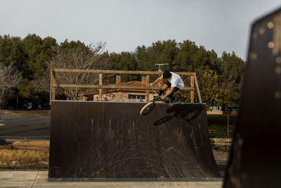 Man skateboarding on skateboard against sky