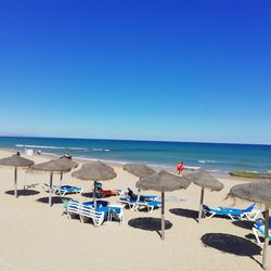 Scenic view of beach against clear blue sky