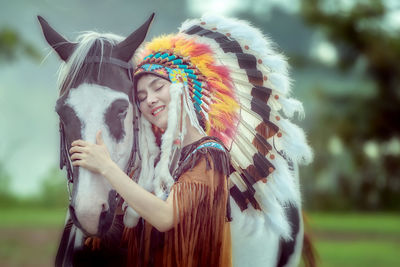 Portrait of smiling young woman holding feathers