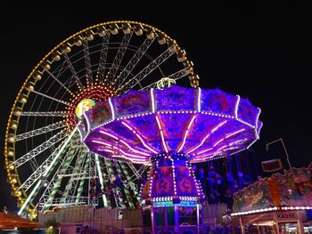 Low angle view of ferris wheel against sky at night