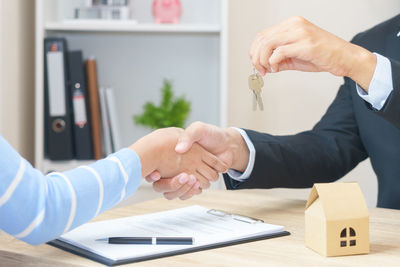 Midsection of couple holding hands on table