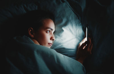 Portrait of boy lying on bed at home