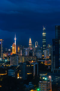 Illuminated buildings in city against sky at night