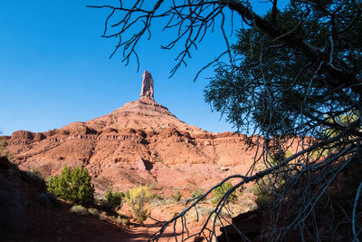 Rock formations on landscape against clear blue sky