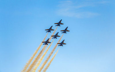 Low angle view of airplane flying against blue sky