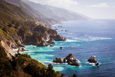 Scenic view of sea and mountains against sky