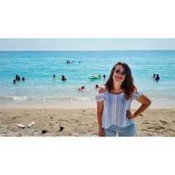 Young woman standing on beach against clear sky