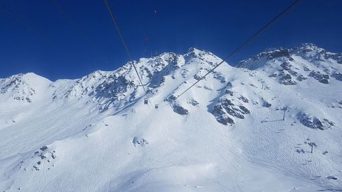 Snow covered mountain against blue sky