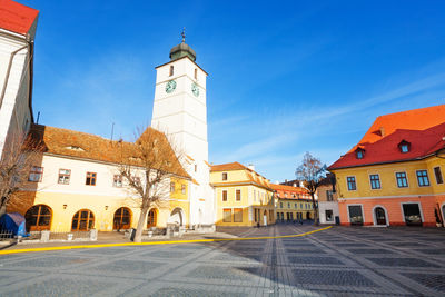 View of buildings in city against blue sky