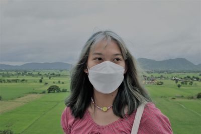 Portrait of beautiful young woman against mountains