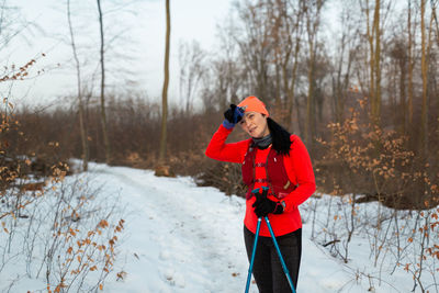 Full length of woman standing on snow covered field