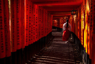 Rear view of woman walking in temple outside building