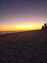 Scenic view of beach against clear sky during sunset