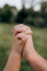 Cropped image of couple holding hands outdoors