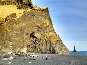 Rock formations by sea against sky