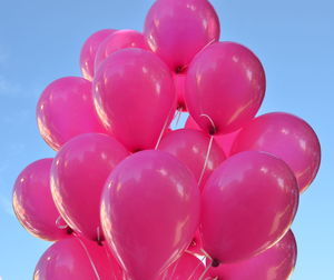 Low angle view of pink balloons against clear sky