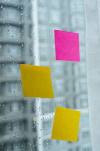 Close-up of yellow umbrella on glass window