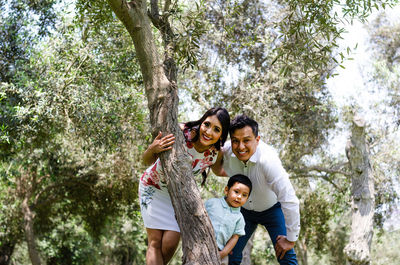 Portrait of happy family by trees